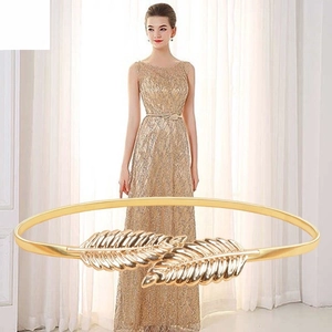 Detailed close-up of golden metal leaf buckle on an elastic stretch waist belt for women