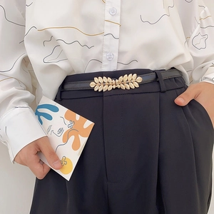Women's thin black leather belt featuring an elegant gold leaf-shaped metal buckle