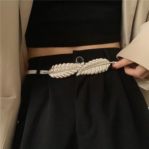 Detail of silver leaf metal waist chain showing fine leaf texture on beige suit jacket