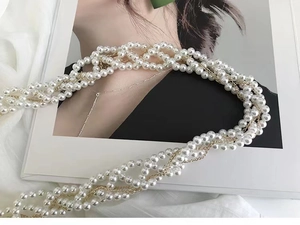 Détail de perles blanches multicouches et chaînes dorées sur fond de magazine de mode