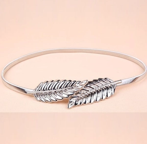 Detailed macro shot of silver feather buckle design on elastic metal leaf waist chain