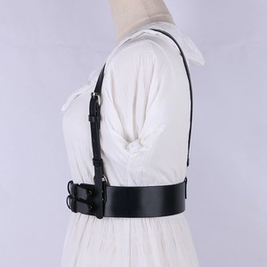 Detailed side view of punk style black leather body harness with silver metal buckles