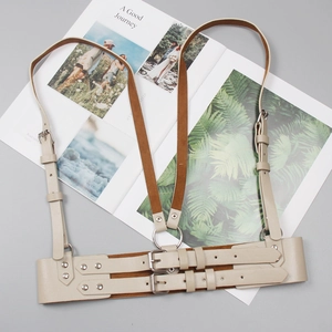Detail of cream PU leather body harness with adjustable metal buckles and punk style rings