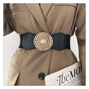 Détail de la ceinture élastique noire avec boucle métallique dorée et perle blanche