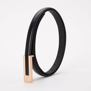 Gros plan sur une ceinture fine en cuir noir avec une boucle rectangulaire dorée élégante