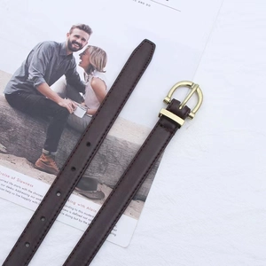 Close-up of slim dark brown leather belt with elegant golden U-shaped buckle on white