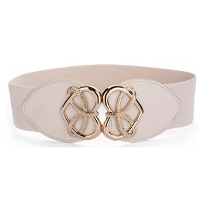 Detail of a beige elastic waist belt featuring a decorative golden hollow heart buckle