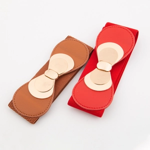 Détail de ceintures larges élastiques avec boucles dorées en nœud, rouge et marron
