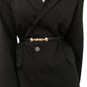 Elegante cintura sottile nera con fibbia di perle dorate su un blazer da donna