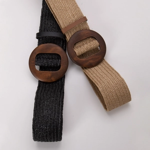 Détail de ceintures bohèmes tressées en paille avec boucles rondes en bois noir et kaki