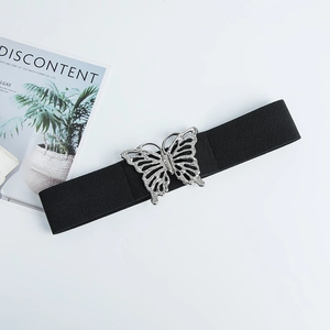 Détail de la boucle papillon argentée avec strass sur une ceinture élastique noire