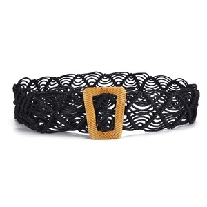 Détail d'une ceinture bohème tressée à la main en corde noire avec boucle en bois texturé