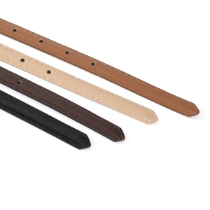 Detail view of narrow PU leather belts in black, brown, and apricot with fine stitching