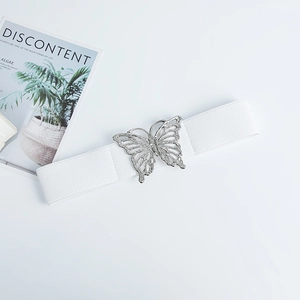 Gros plan sur la boucle papillon argentée et la texture de la ceinture élastique blanche