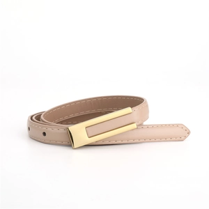 Détail d'une ceinture fine en cuir beige avec boucle rectangulaire dorée et couture fine