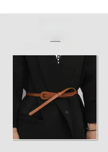 Detail showing a stylish brown leather skinny belt tied in a bow over a black blazer jacket