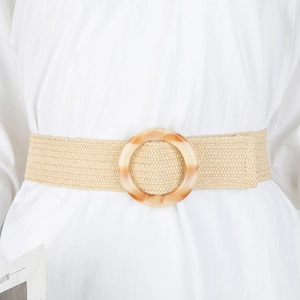 Detail of bohemian straw woven belt with round resin buckle on a white dress