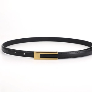 Détail d'une ceinture fine en cuir noir avec une boucle rectangulaire dorée classique