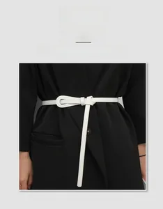 Slim white PU leather tie belt for waist cinching on a suit jacket for women