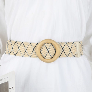 Detail of bohemian straw woven belt with navy diamond patterns and round wooden buckle
