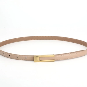 Détail de la ceinture fine en cuir beige avec surpiqûres blanches et boucle dorée