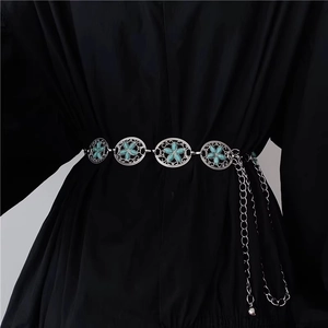 Detail einer Vintage-Silber-Taillenkette mit türkisfarbenen Blumen-Medaillons auf schwarzem Kleid