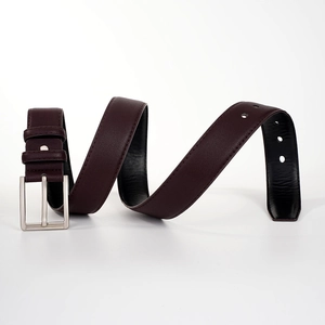 Détail de la ceinture en cuir bordeaux avec boucle à ardillon en métal argenté texturé