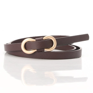 Detailed macro view of dark brown leather texture and matte gold metal buckle on slim belt