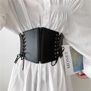 Detail of a black punk corset belt with front zipper and vintage cross-lace sides