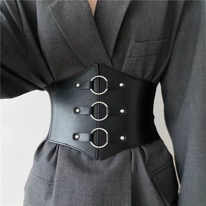 Detail of black PU leather wide waist belt with triple metal rings and silver rivets on suit