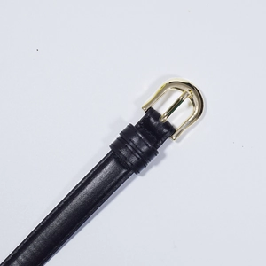 Detail shot of a black vintage leather belt featuring a golden horseshoe pin buckle