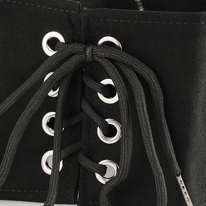 Dettaglio ravvicinato della cintura corsetto nera vintage con occhielli e lacci incrociati