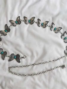 Detail of vintage metal butterfly waist chain featuring turquoise inlays and lobster clasp