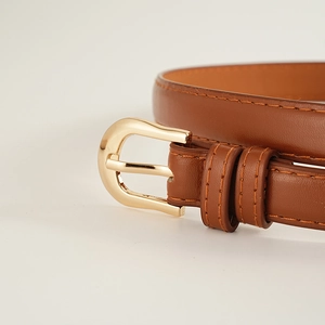 Détails d'une ceinture en cuir marron avec boucle ardillon dorée et coutures fines