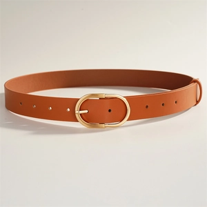 Détail d'une ceinture en cuir marron avec boucle ovale dorée et trous réglables