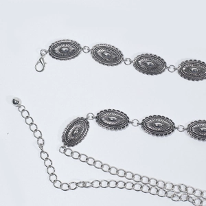 Détail de la ceinture chaîne en métal argenté vintage avec plaques ovales sculptées