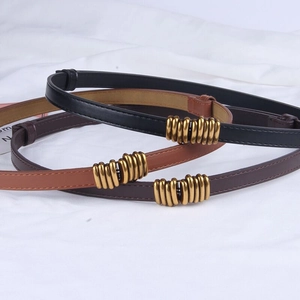 Detailed close-up of retro spiral gold buckles on black, brown and coffee leather belts