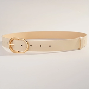Détail d'une ceinture en cuir crème avec boucle ovale dorée et trous réglables
