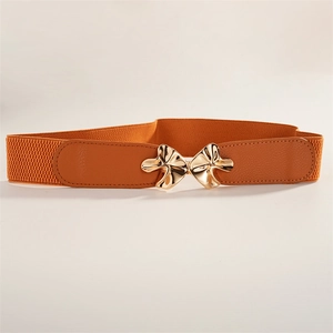 Detail of tan elastic waist belt featuring a golden bow-shaped metal buckle on faux leather