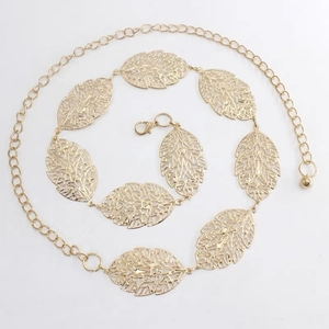 Detail of golden metal waist chain featuring hollow leaf charms and adjustable lobster clasp