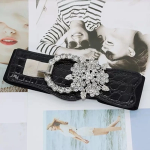 Women's black elastic waist belt with crocodile texture and large floral rhinestone buckle