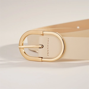 Détail d'une ceinture en cuir crème avec boucle dorée en forme de D et coutures précises