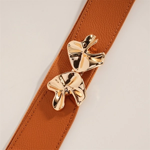 Close-up of brown elastic waist belt with an abstract gold polished metal buckle