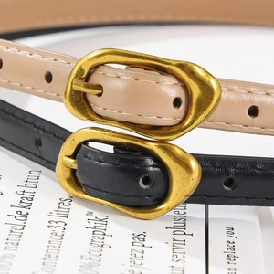 Détails des ceintures fines en cuir noir et beige avec boucles dorées de style vintage