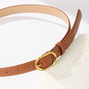 Brown slim women's belt with vintage gold buckle and fine stitching on white stones