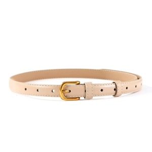 Détail d'une fine ceinture en cuir beige avec boucle dorée mate et couture blanche