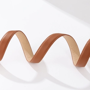 Detailed view of brown leather belt featuring premium texture and uniform stitching