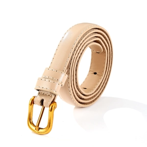 Détail d'une ceinture fine en cuir beige avec surpiqûres blanches et boucle dorée rétro