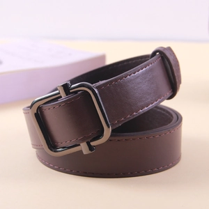 Detail of a vintage dark brown leather belt featuring a gunmetal square pin buckle