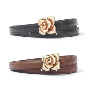 Close-up of elegant rose gold flower metal buckles on slim PU leather belts for women